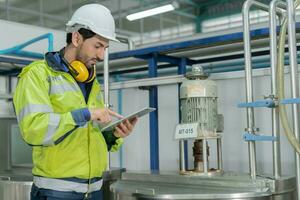 Engineers or factory managers wearing safety helmet inspect the machines in the production line. Utility inspector check machine and test the system to meet the standard. machine, maintenance. photo