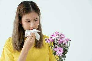 polen alergias, asiático joven mujer estornudos en un pañuelo o soplo en un limpiar, alérgico a salvaje primavera flores o flores durante primavera. alérgico reacción, respiratorio sistema problemas foto