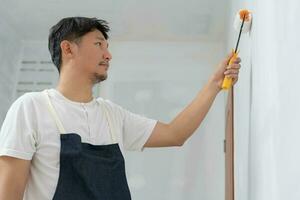 pintor hombre, cepillo en mano para productos a restaurar y pintar el muro, interior el edificio sitio de un casa, pared durante cuadro, renovación, cuadro, contratista, arquitecto, construcción trabajador foto