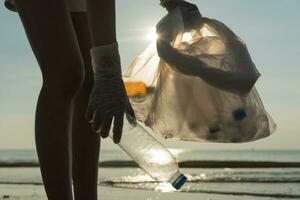 Save water. Volunteer pick up trash garbage at the beach and plastic bottles are difficult decompose prevent harm aquatic life. Earth, Environment, Greening planet, reduce global warming, Save world photo