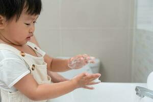 little kid hands wash with soap bubbles and rinse with clean water to prevent and stop the spread of germs after back to home, virus or covid19. Good health and good personal hygiene, virus, bacteria photo