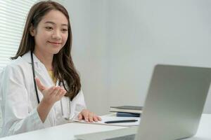 telemedical. Doctors are advising patients over the Internet by video conference. Asian doctor is treating patients through telecommunication while describing the disease . Technology for health. photo