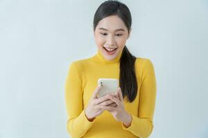 Asian beautiful woman exited surprise face expression . female feels shocked with the phone. exciting smile and happy adorable rejoices. Very enjoy and fun relax time. wow, girl holding smartphone. photo