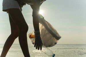 ahorrar agua. los voluntarios recogen basura en la playa y las botellas de plástico son difíciles de descomponer para evitar dañar la vida acuática. tierra, ambiente, planeta verde, reducir el calentamiento global, salvar el mundo foto