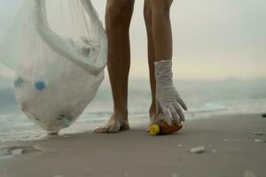 salvar océano. voluntario recoger arriba basura basura a el playa y el plastico botellas son difícil descomponer evitar daño acuático vida. tierra, ambiente, verdeado planeta, reducir global calentamiento, salvar mundo foto