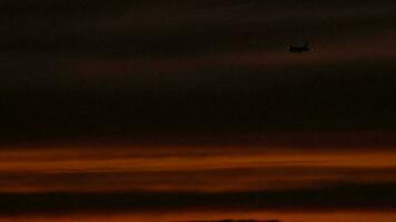 de vliegtuig Aan de laatste nadering voordat landen Aan de achtergrond van de zonsondergang schemer lucht video