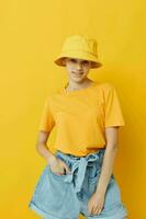 optimistic young woman in a yellow hat Youth style casual wear isolated background photo