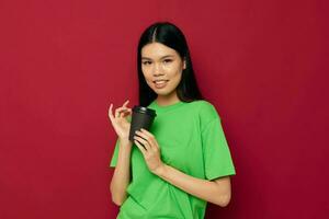 pretty brunette posing in a green t-shirt disposable black glasses red background unaltered photo