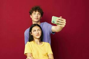 a young couple modern style emotions fun phone red background photo