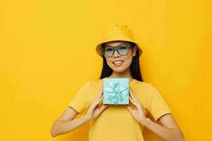 cheerful woman with gift box in hat and glasses photo