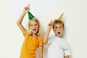 picture of positive boy and girl in multicolored caps birthday holiday emotion light background photo