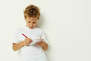 Boy draws with pencil in notebook entertainment studio photo