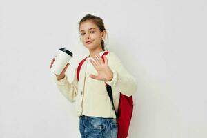 schoolgirl with a red backpack a glass with a drink in her hands photo