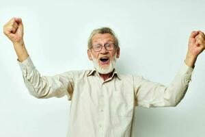 Senior grey-haired man with a gray beard in a shirt and glasses light background photo