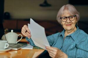 Beautiful mature senior woman sitting in a cafe with a cup of coffee and a laptop Lifestyle unaltered photo