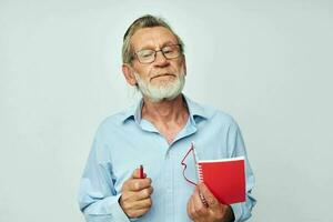Portrait of happy senior man red notepad writing light background photo