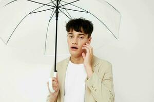 nice young guy with an open umbrella in a suit light background photo
