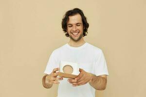 emotional man with gift small box on beige background photo