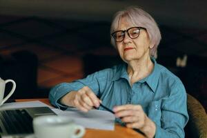 Beautiful mature senior woman documents work sheet of paper and pen Social networks unaltered photo