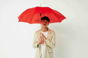 un joven hombre rojo paraguas un hombre en un ligero chaqueta aislado antecedentes inalterado foto