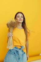 beautiful woman wearing a hat dry flowers summer style yellow background photo