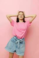 young beautiful woman in a pink t-shirt casual clothes pink background photo