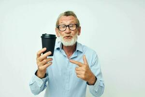 Senior grey-haired man with a black glass in his hands a drink isolated background photo