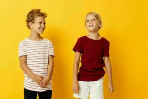 Small children casual wear games fun together yellow background photo