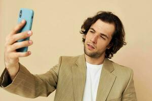 Attractive man in a suit posing emotions looking at the phone isolated background photo