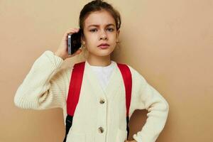 linda niña hablando en el teléfono con un mochila infancia inalterado foto