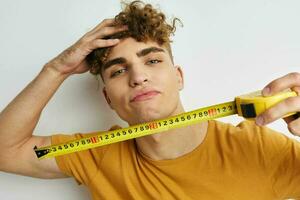 Attractive man grimace measuring tape posing Lifestyle unaltered photo
