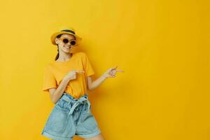 optimistic young woman in a yellow hat Youth style casual wear in sunglasses Lifestyle unaltered photo