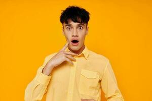 handsome man in yellow shirt posing emotions yellow background photo