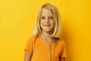 retrato de un pequeño niña en un amarillo camiseta sonrisa posando estudio infancia estilo de vida inalterado foto