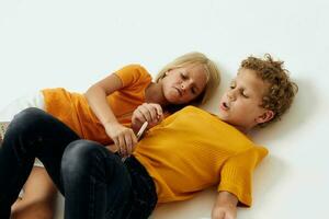 Cute stylish kids lie on the floor with notepads and pencils childhood lifestyle unaltered photo