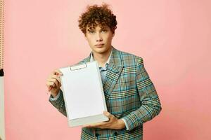 Young curly-haired man in a business suit copy-space documents isolated background unaltered photo