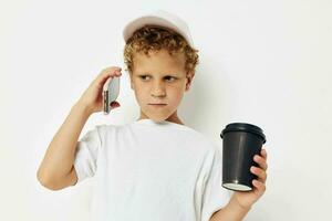 Photo portrait curly little boy talking on the phone with a black glass isolated background unaltered