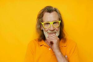 Portrait of happy senior man in yellow glasses with a gray beard emotions cropped view photo