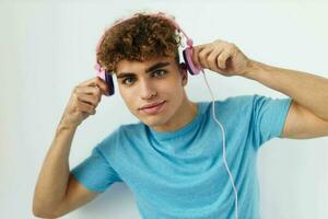 handsome young man in blue t-shirts pink headphones fashion isolated background photo