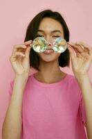 short haired brunette glasses in the form of diamonds in a pink t-shirt isolated background photo