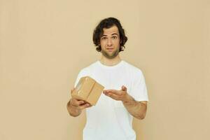 Cheerful man in a white t-shirt with a gift box photo