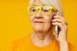 sonriente mayor mujer en casual camiseta comunicación por teléfono de cerca emociones foto