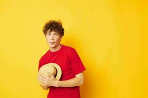 cute red-haired guy emotions red t-shirt hat studio yellow background unaltered photo