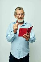 Photo of retired old man with red notebook and pen isolated background
