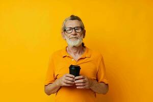 Portrait elderly man with black disposable cup yellow background photo