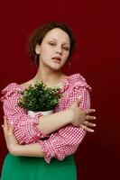woman in pink blouse flower potted posing red background unaltered photo