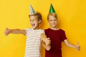 Small children holiday fun with caps on your head yellow background photo