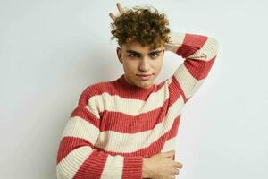 Attractive man in a striped sweater posing light background photo