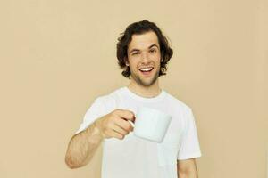 Cheerful man with a white mug in his hands emotions posing beige background photo
