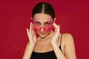 Sexy brunette woman in pink glasses makeup emotions cosmetics isolated background unaltered photo